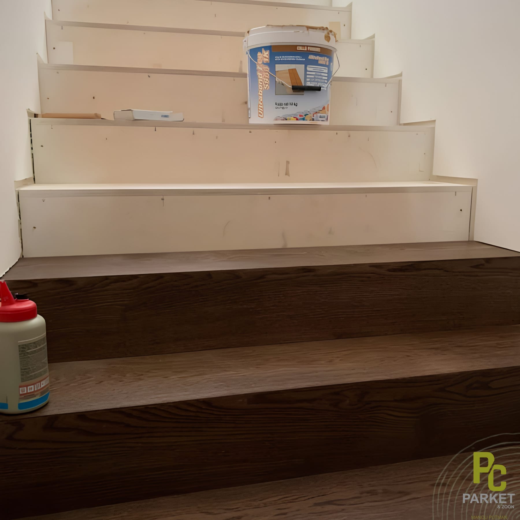 Trap halverwege de bekleding: de onderste treden zijn al in donker hout afgewerkt